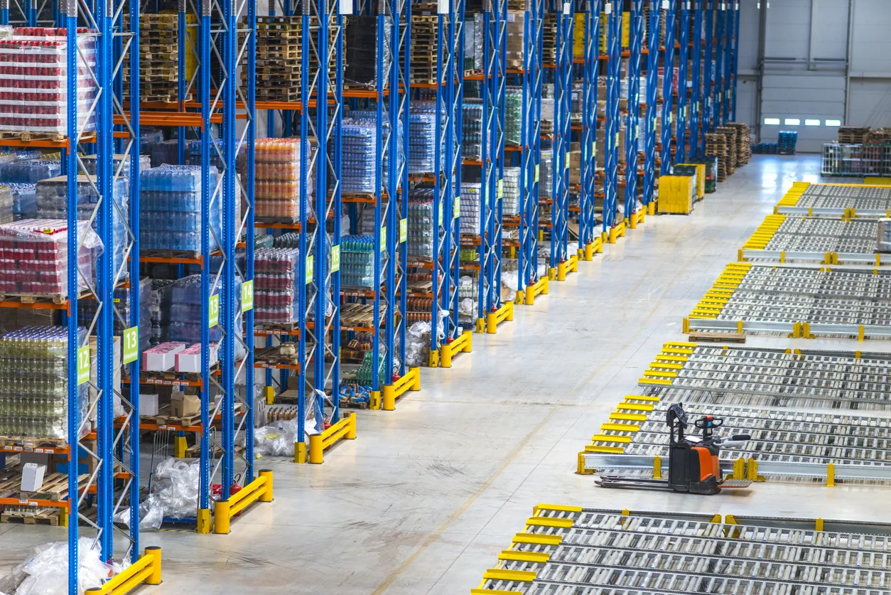 Distribution warehouse interior. Top view of large storage area with goods on the shelf and forklifts.